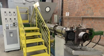 A imagem mostra uma extrusora, uma máquina de reciclagem de plástico que transforma o polímero em pellets.
