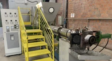 A imagem mostra uma extrusora, uma máquina de reciclagem de plástico que transforma o polímero em pellets.